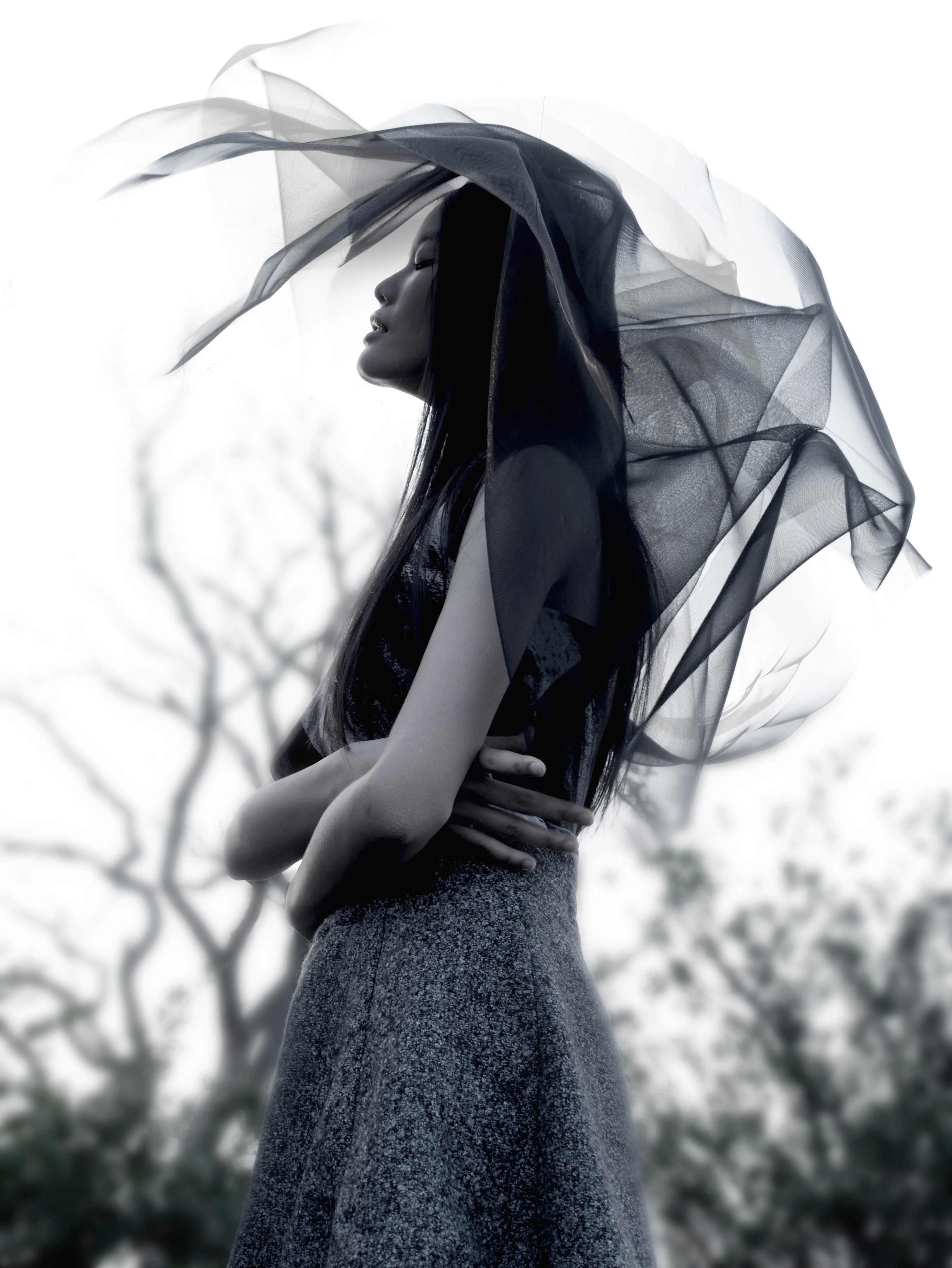 Black-and-white conceptual portrait with flowing fabric